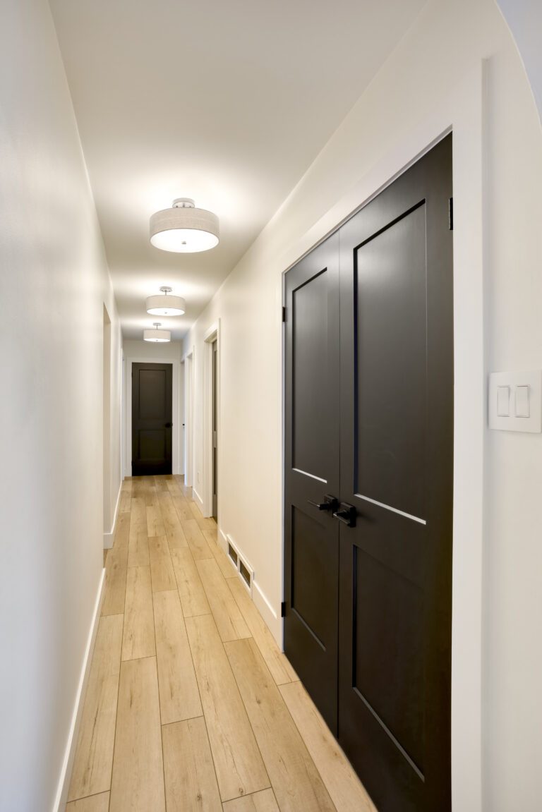 Interior hallway with white walls and black panel doors finished with an HVLP sprayer by GreenTech Painting in London, Ontario