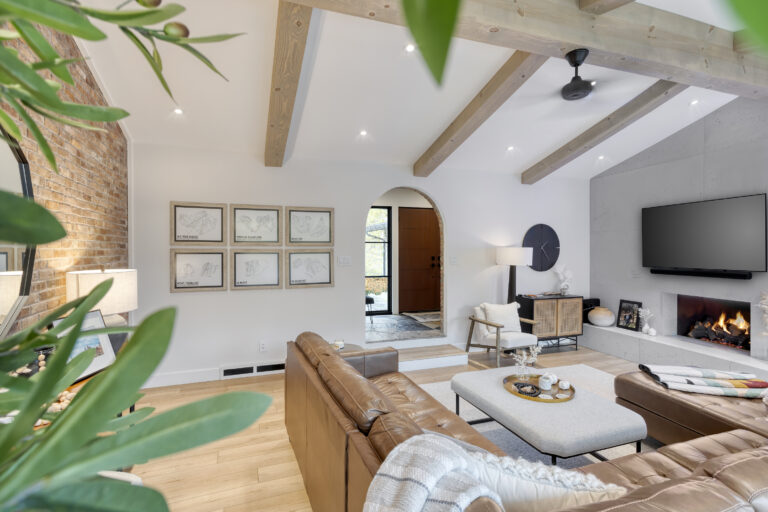 Open concept living room with vaulted wood beams, exposed brick wall and eco-friendly painted ceiling by GreenTech Painting in London, Ontario