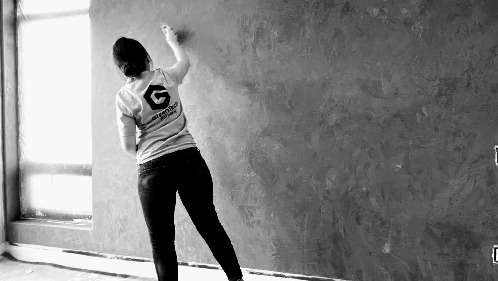 GreenTech Painting artisan hand-applying a custom decorative stucco finish to an interior feature wall in London, Ontario.