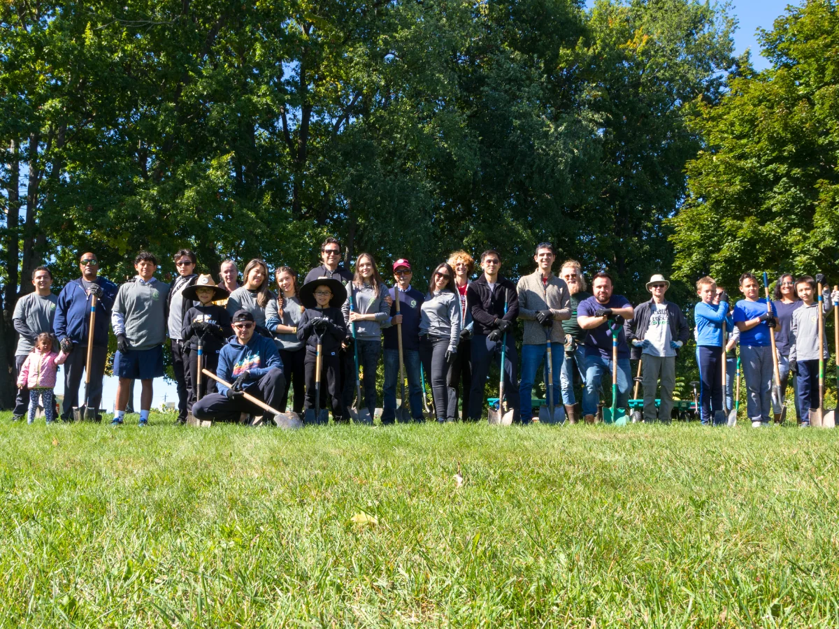 Community volunteers participating in a tree planting initiative supported by GreenTech Painting to promote environmental sustainability in London, Ontario.