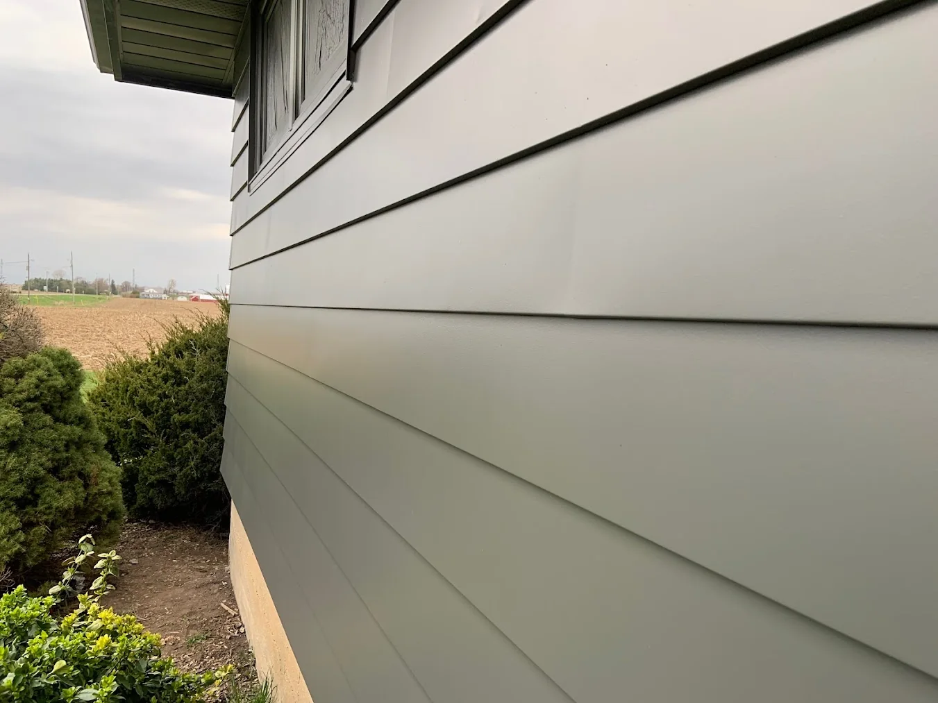 Professionally painted grey aluminum siding on a residential home by GreenTech Painting in London, Ontario.