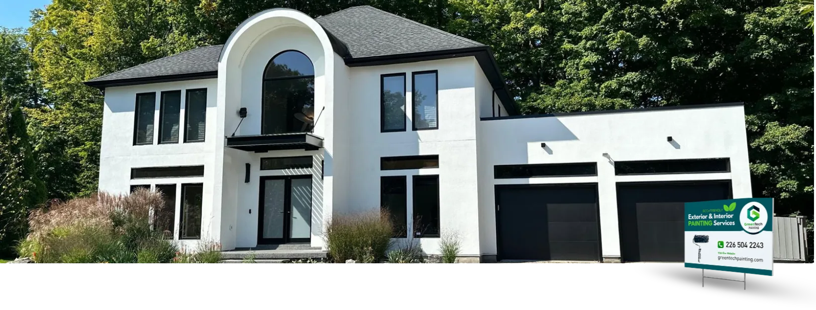 Award-winning exterior house painting featuring a modern white home with black accents by GreenTech Painting in London, Ontario.