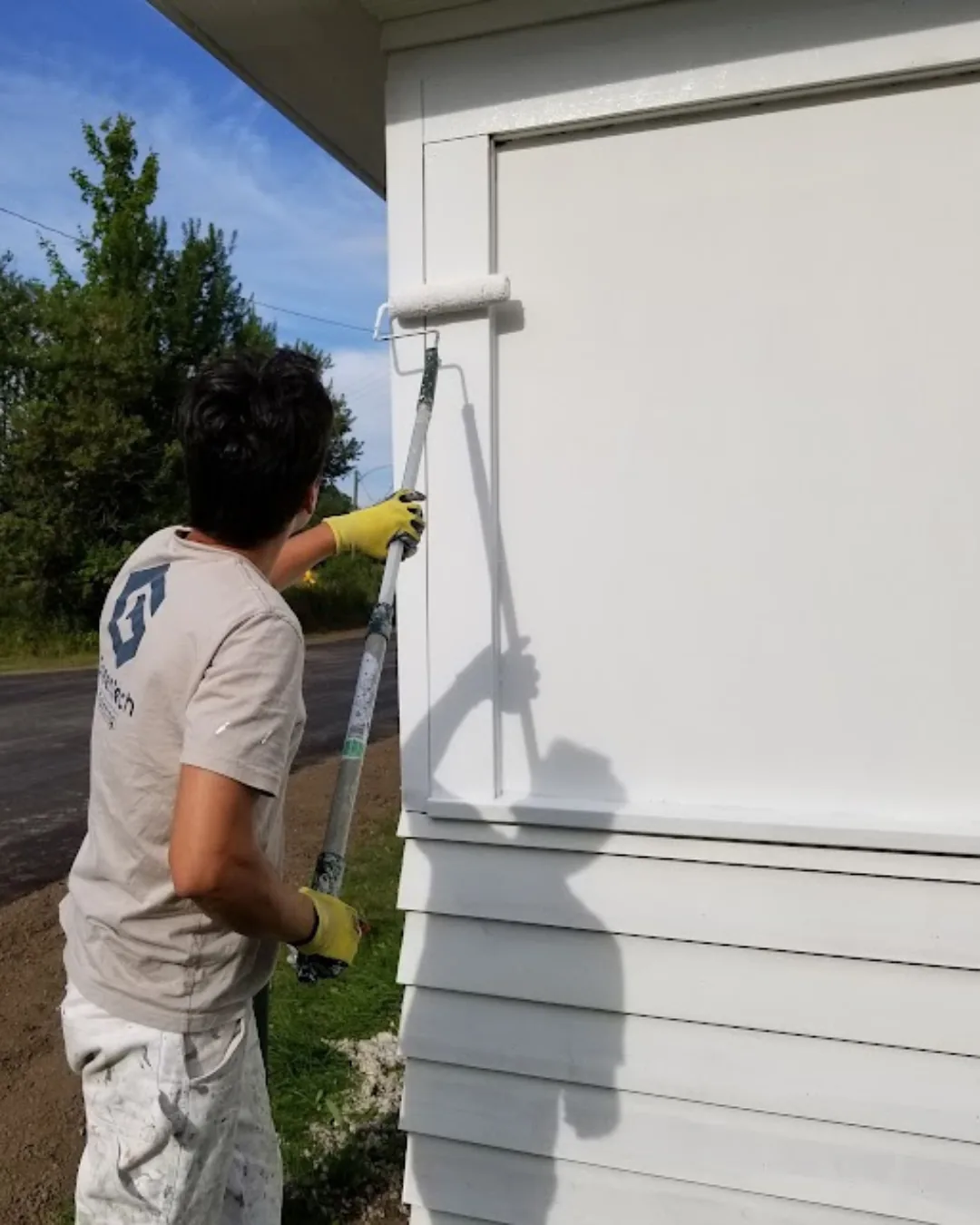 Professional exterior wood siding painting on a residential home by GreenTech Painting in London, Ontario.