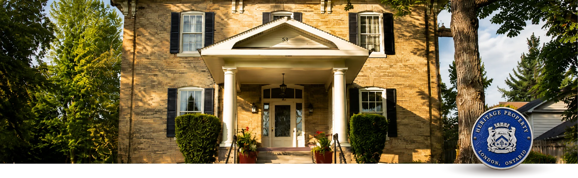 Historic brick home in London, Ontario featuring restored exterior trim, shutters, soffits and decorative architectural details.