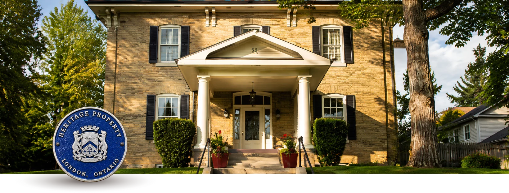 Restored heritage brick home with a designated Heritage Property plaque in London, Ontario.