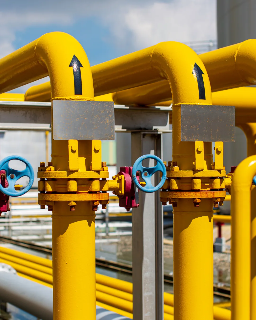 Industrial piping and valves with durable yellow protective coatings representing professional industrial painting services in London, Ontario.