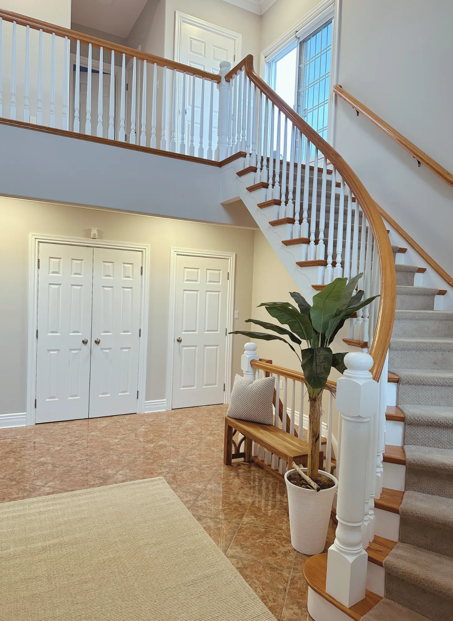 Award-winning interior house painting featuring a bright foyer, elegant staircase, and professionally painted walls by GreenTech Painting in London, Ontario.
